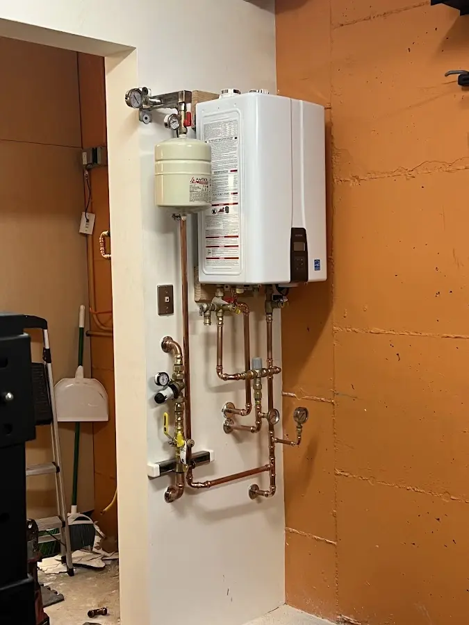 Plumbing technician inspecting water heater connections in Spring Valley